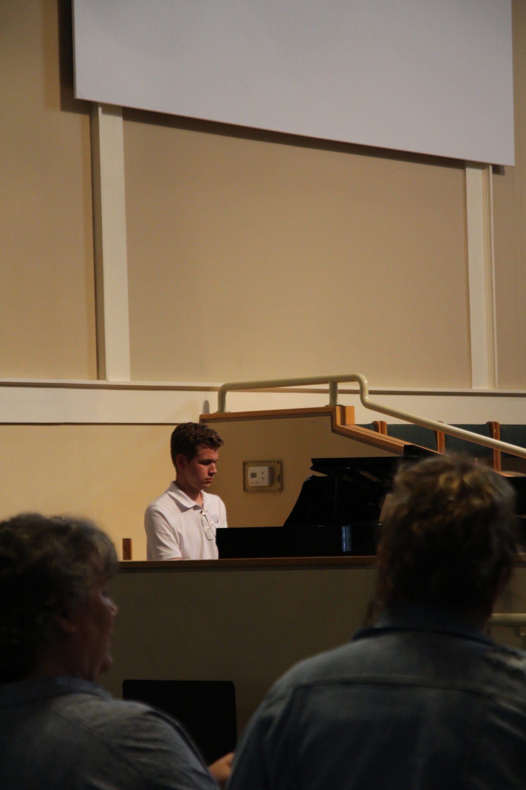 Student playing piano for Christian chapel at Coram Deo Classical School.