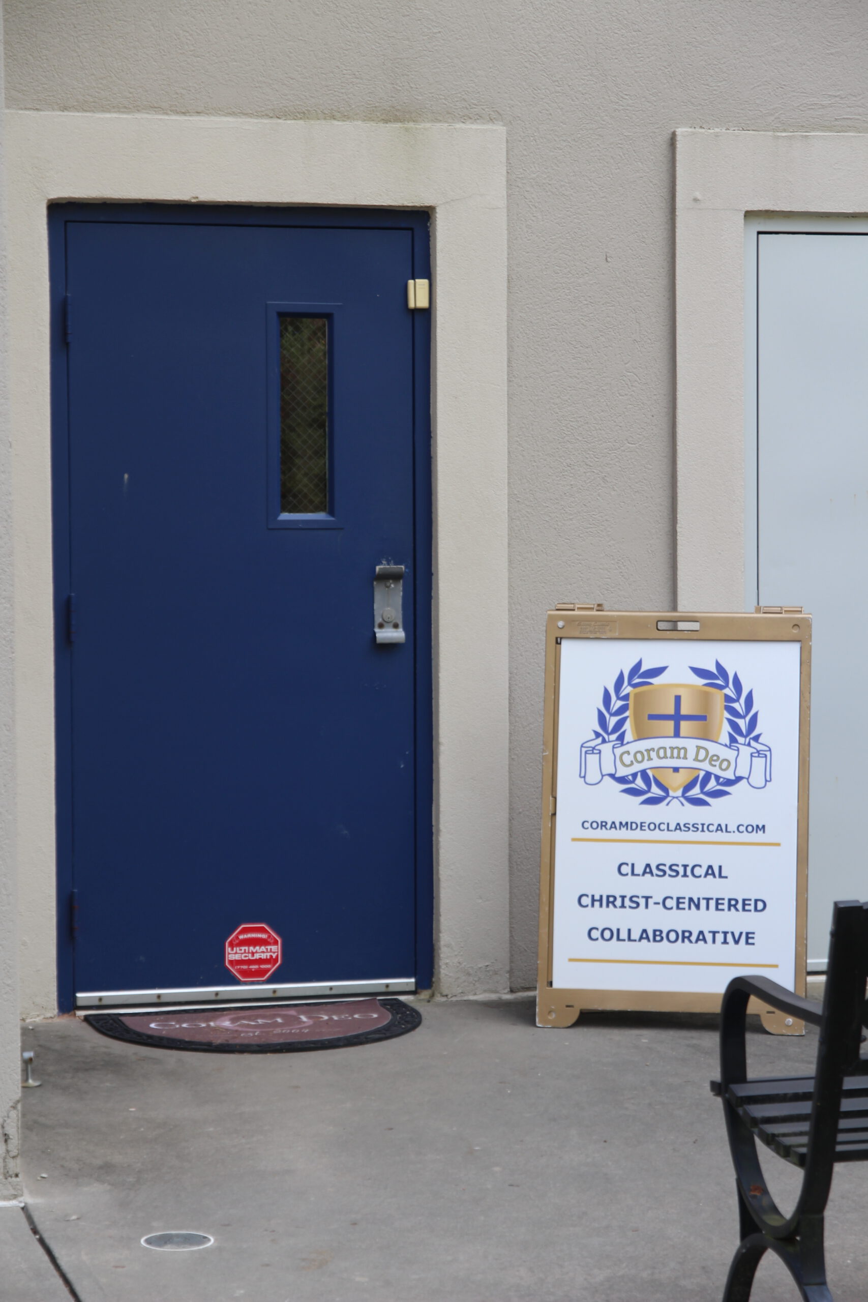 Front door of Coram Deo Classical School with sign saying Classical, Christ-centered, and collaborative.